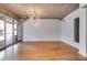 Bright living room with hardwood floors, exposed concrete ceilings and a modern chandelier at 890 Memorial Se Dr # 105, Atlanta, GA 30316
