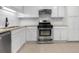 Kitchen features stainless steel appliances, white cabinets, neutral counters and tiled backsplash at 907 Parkaire Xing, Marietta, GA 30068