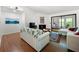 Bright living room features sliding glass doors to balcony, hardwood floors, and white sofas at 907 Parkaire Xing, Marietta, GA 30068