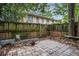 Backyard with a stone patio and a wooden fence surrounded by trees at 100 Biscayne Nw Dr # A1, Atlanta, GA 30309