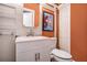 Orange-themed bathroom featuring a white vanity, mirrored cabinet, and artistic wall decor at 100 Biscayne Nw Dr # A1, Atlanta, GA 30309