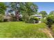 Spacious backyard with an indoor pool room, mature trees, and green lawn, perfect for outdoor activities at 239 Kings Hwy, Decatur, GA 30030