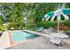 Relaxing pool area with mature landscaping, an umbrella table and several lounge chairs for easy outdoor living at 239 Kings Hwy, Decatur, GA 30030