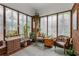 Bright sunroom with large windows, brick walls, and comfortable seating surrounded by potted plants at 239 Kings Hwy, Decatur, GA 30030