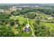 Aerial view of a rural estate featuring a home with well-manicured grounds surrounded by lush woodlands at 5945 Bannister Rd, Cumming, GA 30028