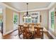 Light-filled dining room features wood floors, a rustic table, and a view of the outdoors at 5945 Bannister Rd, Cumming, GA 30028