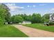 Long driveway leading to a charming home with lush green landscaping, outbuildings, and a spacious yard at 5945 Bannister Rd, Cumming, GA 30028