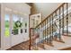 Inviting foyer featuring a decorative staircase, patterned rug, and glass paneled front door at 5945 Bannister Rd, Cumming, GA 30028