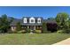 Charming red brick home featuring manicured lawn and mature landscaping at 5945 Bannister Rd, Cumming, GA 30028