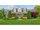 Charming brick home featuring dormer windows, manicured landscaping, and a welcoming covered front porch at 5945 Bannister Rd, Cumming, GA 30028