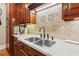 Kitchen showcases stainless steel sink, custom cabinets, granite counters, and decorative tile backsplash at 5945 Bannister Rd, Cumming, GA 30028