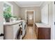 Bright laundry room with modern washer and dryer, ample counter space, and natural light at 5945 Bannister Rd, Cumming, GA 30028