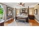 Serene main bedroom with a four-poster bed, hardwood floors, and natural light from a large window at 5945 Bannister Rd, Cumming, GA 30028