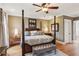 Spacious main bedroom with hardwood floors, a four-poster bed, and elegant furnishings at 5945 Bannister Rd, Cumming, GA 30028