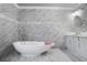 Modern bathroom featuring marble tile, standalone tub, dual vanity, and stylish fixtures at 1560 Sarah M Harden Dr, Atlanta, GA 30311