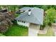 Aerial view showcasing a well-maintained white home with a grey roof, landscaped yard, and covered driveway at 2298 Pembrook Pl, Atlanta, GA 30324