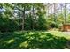 Expansive backyard with lush green grass, mature trees, and a storage shed at 2298 Pembrook Pl, Atlanta, GA 30324