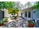 Inviting outdoor patio features a stone surface, dining set with umbrella, and lush potted plants at 2298 Pembrook Pl, Atlanta, GA 30324