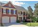 Charming brick home with a two-car garage, black shutters, and manicured landscaping at 475 Vinings Estates Se Dr # A03, Smyrna, GA 30126
