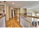 Open hallway with hardwood flooring, white railings, and built-in shelving, creating an inviting transition space at 475 Vinings Estates Se Dr # A03, Smyrna, GA 30126