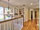 Hallway with hardwood floors, built-in bookshelves, a chandelier, and large windows providing natural light at 475 Vinings Estates Se Dr # A03, Smyrna, GA 30126