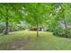 Large, lush backyard with mature trees and view of the home at 845 Stratford Rd, Avondale Estates, GA 30002
