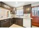 Cozy kitchen with granite countertops, dark wood cabinets, and a stainless steel sink under the window at 845 Stratford Rd, Avondale Estates, GA 30002