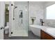 Modern bathroom featuring a sleek glass shower, standalone tub, and marble-look tiling at 1063 Manigault Se St, Atlanta, GA 30316