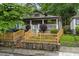 Inviting bungalow home featuring a charming front porch, wooden fence, and beautifully landscaped yard at 1063 Manigault Se St, Atlanta, GA 30316