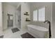 Bright bathroom featuring a soaking tub, shutters, and a glass shower at 1892 Raven Hill Ne Dr, Atlanta, GA 30319