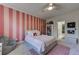 Stylish bedroom featuring a bed, shelving, pink striped accent wall and comfortable furnishings at 1892 Raven Hill Ne Dr, Atlanta, GA 30319