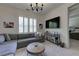 Comfortable living room featuring a gray couch, round wood table, TV, and modern chandelier at 1892 Raven Hill Ne Dr, Atlanta, GA 30319