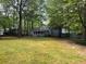 Rear view of home with large grassy backyard and tree coverage at 3262 Bluff Rd, Marietta, GA 30062
