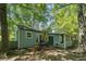 Backyard with lush trees, patio seating, a brick firepit, and partially fenced yard at 3262 Bluff Rd, Marietta, GA 30062