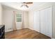 Well-lit bedroom featuring hardwood floors, a ceiling fan, double door closet, and a window view at 3262 Bluff Rd, Marietta, GA 30062