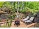 Charming backyard patio with stone pavers, a fire pit, lounge chairs, and lush greenery for a relaxing outdoor retreat at 360 Parkview Manor Dr, Tucker, GA 30084