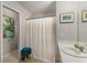 Cozy bathroom with neutral tones, decorative art, shower with curtain, stool, and a single sink vanity at 360 Parkview Manor Dr, Tucker, GA 30084