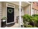 Inviting front porch with elegant wreath, potted plants, and cozy bench seating at 360 Parkview Manor Dr, Tucker, GA 30084