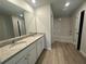 Bathroom featuring double sink vanity, laminate floor, mirror, and tub with shower at 45 Emerald Ln, Covington, GA 30014