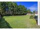 Expansive backyard with vibrant green grass, mature trees, wood fence, and a swing set for outdoor fun at 4765 Smokestone Dr, Douglasville, GA 30135