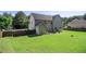 A spacious backyard featuring a green lawn, a wood fence, and the rear of the house with a small shed and patio at 4765 Smokestone Dr, Douglasville, GA 30135