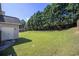 Lush backyard with healthy green grass, bordered by mature trees and a wood fence, plus a 2 door storage shed at 4765 Smokestone Dr, Douglasville, GA 30135