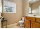 Neutral bathroom with a single sink vanity, toilet, tiled floor, and a window providing natural light at 4765 Smokestone Dr, Douglasville, GA 30135