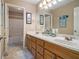Bright bathroom with double sinks, wood cabinets, large mirror, and stylish decor for a relaxing experience at 4765 Smokestone Dr, Douglasville, GA 30135