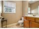 A cozy bathroom showcasing a classic toilet, vanity with storage, neutral color palette, and natural light at 4765 Smokestone Dr, Douglasville, GA 30135