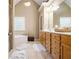 Bathroom featuring wood cabinetry and a soaking tub with bright natural light at 4765 Smokestone Dr, Douglasville, GA 30135