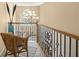 Hallway featuring wrought iron spindles, wood railing, chandelier, and sitting area at 4765 Smokestone Dr, Douglasville, GA 30135