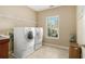 Functional laundry room with washer, dryer, and storage shelves at 4765 Smokestone Dr, Douglasville, GA 30135