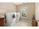 Functional laundry room with front-load washer and dryer, wire shelving, and a window for natural light at 4765 Smokestone Dr, Douglasville, GA 30135