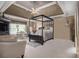Spacious primary bedroom with tray ceiling, canopy bed, sitting area, and lots of natural light at 4765 Smokestone Dr, Douglasville, GA 30135
